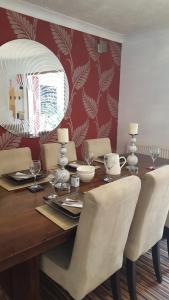 a dining room table with chairs and a mirror at Telscombe Cliffs Bed and Breakfast in Rottingdean