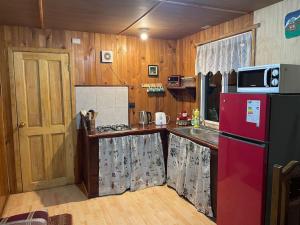cocina con nevera roja y encimera en hermosa cabaña rustica en Puerto Montt