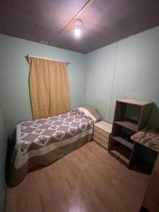 Habitación pequeña con cama y ventana en hermosa cabaña rustica en Puerto Montt