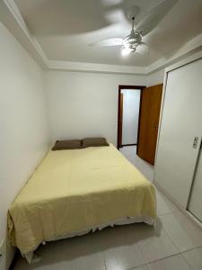 a bedroom with a bed in a white room at Enseada Azul - Apto 150m da Praia de Peracanga in Guarapari