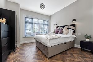 a bedroom with a large bed and a window at Lovely 2 BR with Grill in London