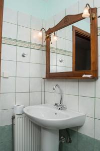 y baño con lavabo y espejo. en Adilon, en Tsagkarada