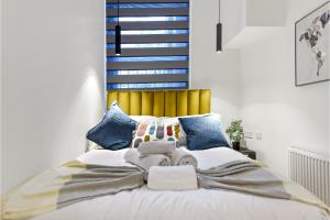 a bedroom with a large white bed with blue pillows at Lovely 2 BR with Grill in London