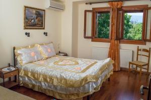 a bedroom with a bed and a chair and a window at Adilon in Tsagarada