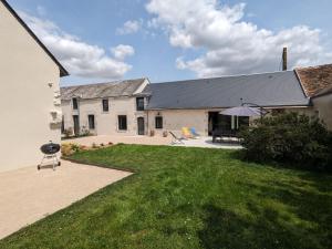 una grande casa bianca con un cortile con un grill di Gîte spacieux et rénové avec jardin, proche châteaux de la Loire, pour 10 pers. - FR-1-590-361 a Huisseau-sur-Mauves