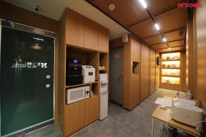 a room with a kitchen with a door and a microwave at Number 25 Hotel in Gwangju