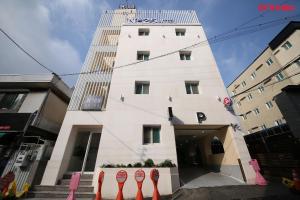 a white building with red parking meters in front of it at Number 25 Hotel in Gwangju