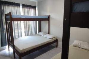 Un dormitorio con dos literas en una habitación. en CASA INDIVIDUAL CoM PISCINA, AR, WI-FI, ATÉ 16 PESSOAS, en Itapema