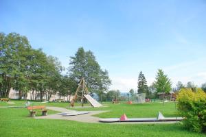 a park with a playground with a slide and benches at RELAX-ROSÉ mit Pool und Sauna in Scheidegg