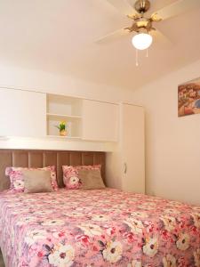 a bedroom with a bed with pink flowers on it at Family friendly house with a swimming pool Vinovac, Zagora - 22041 in Blizna Donja