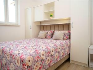 a bedroom with a bed with a floral bedspread at Family friendly house with a swimming pool Vinovac, Zagora - 22041 in Blizna Donja