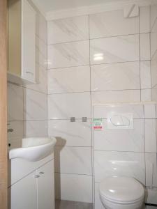 a white bathroom with a toilet and a sink at Family friendly house with a swimming pool Vinovac, Zagora - 22041 in Blizna Donja