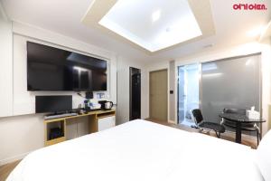 a hotel room with a bed and a flat screen tv at Number 25 Hotel in Gwangju