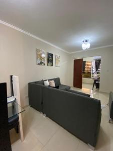 a living room with a black couch and a table at Seguridad y tranquilidad apartamento de 3 camas y 3 habitaciones!! in La Javilla