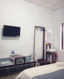 sypialnia z łóżkiem i telewizorem na ścianie w obiekcie Homestay Vườn nhãn w mieście Pleiku