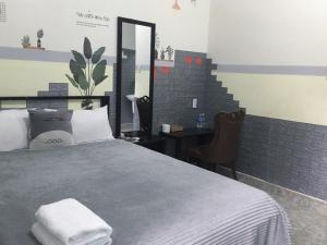 a bedroom with a bed with a mirror and a desk at Homestay Vườn nhãn in Pleiku
