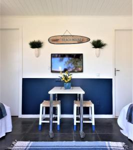 a dining room with a table and two stools at Anexo Hóspedes com Acesso Independente junto Praia in Búzios