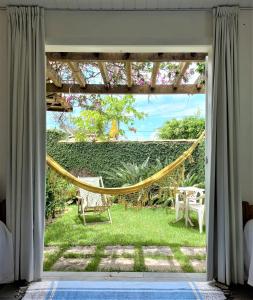 a room with a hammock in the yard at Anexo Hóspedes com Acesso Independente junto Praia in Búzios