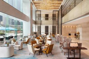 a lobby of a hotel with tables and chairs at Courtyard by Marriott Zhengzhou East in Zhengzhou