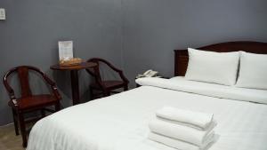 Bình Minh Hotel في مدينة هوشي منه: غرفة فندق عليها سرير وفوط