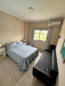 a bedroom with a bed and a chair and a window at Edificio Rivera Este in Colón