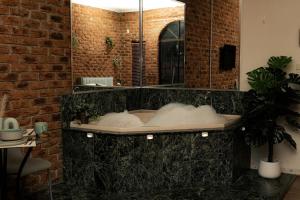 a bathroom with a bath tub with a mirror at Charming Studio by the Beach with Hot Tub in Frankston
