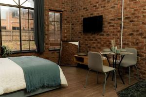 a bedroom with a bed and a table and a brick wall at Charming Studio by the Beach with Hot Tub in Frankston