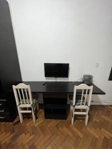 a black desk with two chairs and a computer monitor at Flat Copacabana Posto 4 in Rio de Janeiro