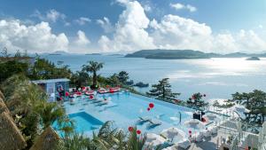 a large swimming pool with a view of the water at Yeosu Calacatta Hotel & Resort in Yeosu