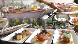 a table with plates of food and glasses of wine at Premier Hotel Nakajima Park Sapporo in Sapporo