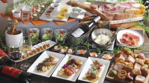 Premier Hotel Nakajima Park Sapporo في سابورو: طاولة مليئة بأطباق الطعام وكؤوس من النبيذ