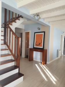 a hallway with a staircase and a painting on the wall at Casa a 100 metros del mar, garaje doble in Mar del Plata