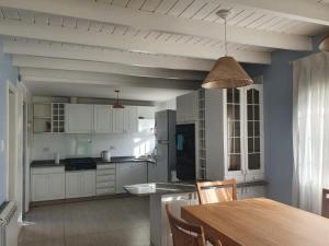 uma cozinha com armários brancos e uma mesa de madeira em Casa a 100 metros del mar, garaje doble em Mar del Plata