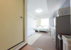a room with a refrigerator and a bedroom with two beds at Hirojo Building 203,303,403,603,703 - Vacation STAY 15419 in Tokyo