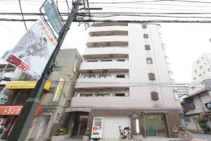 um edifício alto e branco com um cão à frente. em Hirojo Building 203,303,403,603,703 - Vacation STAY 15419 em Tóquio