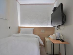 a bedroom with a bed and a flat screen tv at J5 Hostel in Seoul