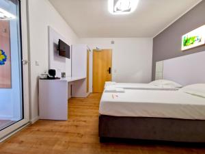 una camera d'albergo con 2 letti e una scrivania di Home Inn Hotel a Dormagen