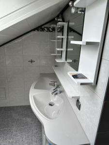a white bathroom with a sink and a mirror at Apartment Oase 2, Parkplatz, Küche, Internet in Klosterlechfeld