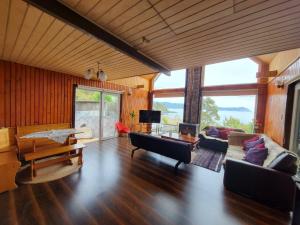 a living room with wooden walls and a large window at Acogedora Cabaña en la playa in Valdivia