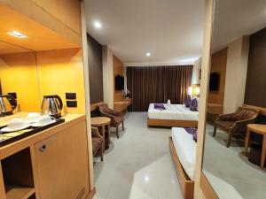 a hotel room with a bedroom and a bed and a kitchen at Masters Suites Hotel in Makkasan +12 photos