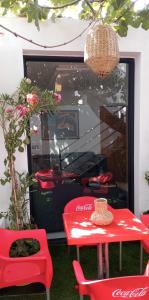 einem roten Tisch und Stühlen vor einem Fenster in der Unterkunft maison costa del sol in Asilah
