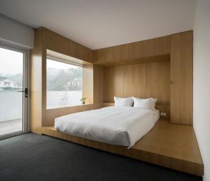 a bedroom with a large bed with a large window at Aventree Hotel in Hangzhou