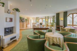 a restaurant with green chairs and tables and a fireplace at Kurhotel Leonardo in Gmünd