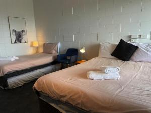 2 Betten in einem Hotelzimmer mit Handtüchern darauf in der Unterkunft Kilcunda Ocean View Motel in Kilcunda