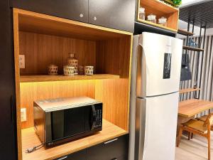 uma cozinha com um micro-ondas e um frigorífico em STAY ID Vida Urbana em Goiânia