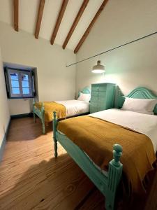1 dormitorio con 2 camas y ventana en Casa Azul d'Óbidos, en Óbidos