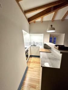 a kitchen with white cabinets and a black counter top at Casa Azul d'Óbidos in Óbidos