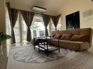 een woonkamer met een bank en een glazen tafel bij D JANNAH HOMESTAY SERI ISKANDAR PERAK in Seri Iskandar
