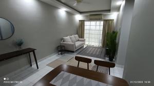 - un salon avec un canapé et une chaise dans l'établissement Homestay Saujana Aster @ Putrajaya, à Putrajaya