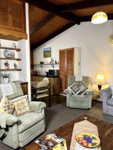 a living room with two chairs and a table at Grassvale Farms Retreat - Lodge in Lindenow